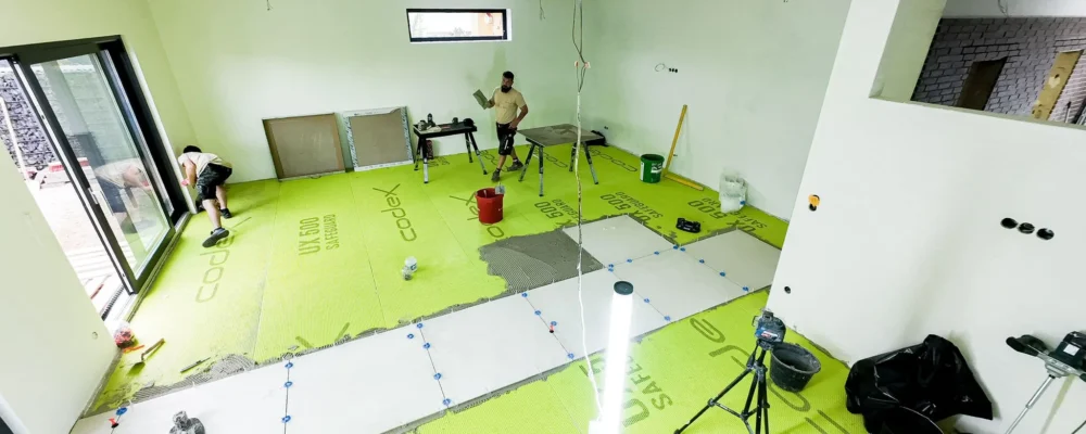 Uebersicht einer Baustelle mit Entkopplungsmatte und ersten verlegten Fliesen